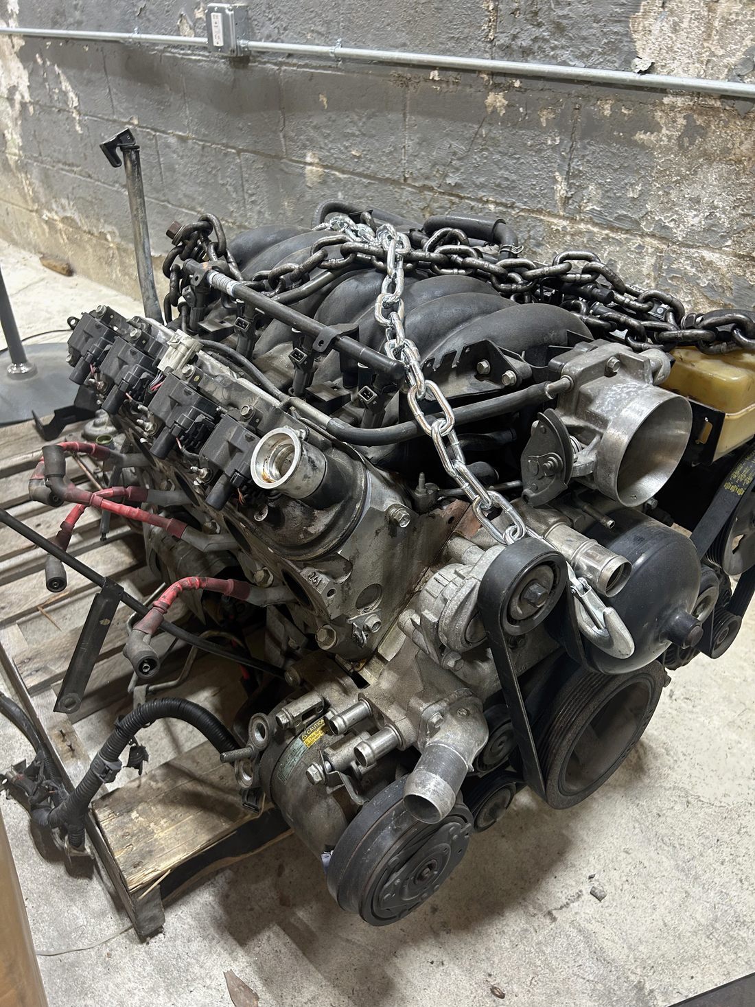 A truck engine sitting on the ground outside of truck